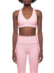 Model showcasing Halter Cropped Sports Bra in pink, paired with matching activewear bottoms.