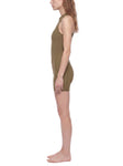 Side view of a model wearing a Quarter-Zip Yoga Romper in olive green, showcasing its athletic fit.